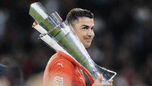 Cristiano Ronaldo, com a camisa de Portigal, segurando o troféu da Nations League sobre os ombros.