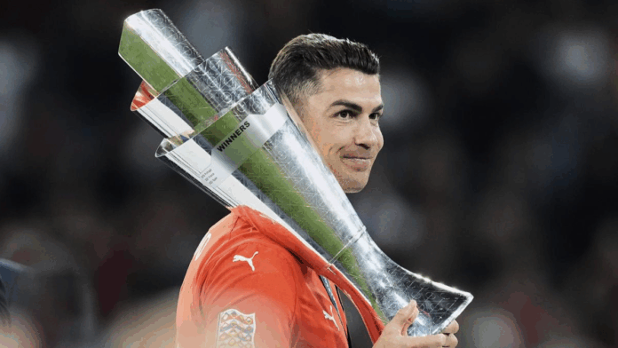 Cristiano Ronaldo, com a camisa de Portigal, segurando o troféu da Nations League sobre os ombros.
