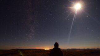 Em imagem ilustrativa, pessoa observa um eclipse se formando