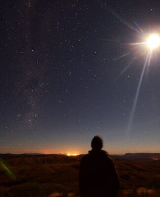Em imagem ilustrativa, pessoa observa um eclipse se formando