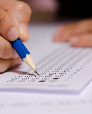Em imagem ilustrativa, jovem completa gabarito de prova.