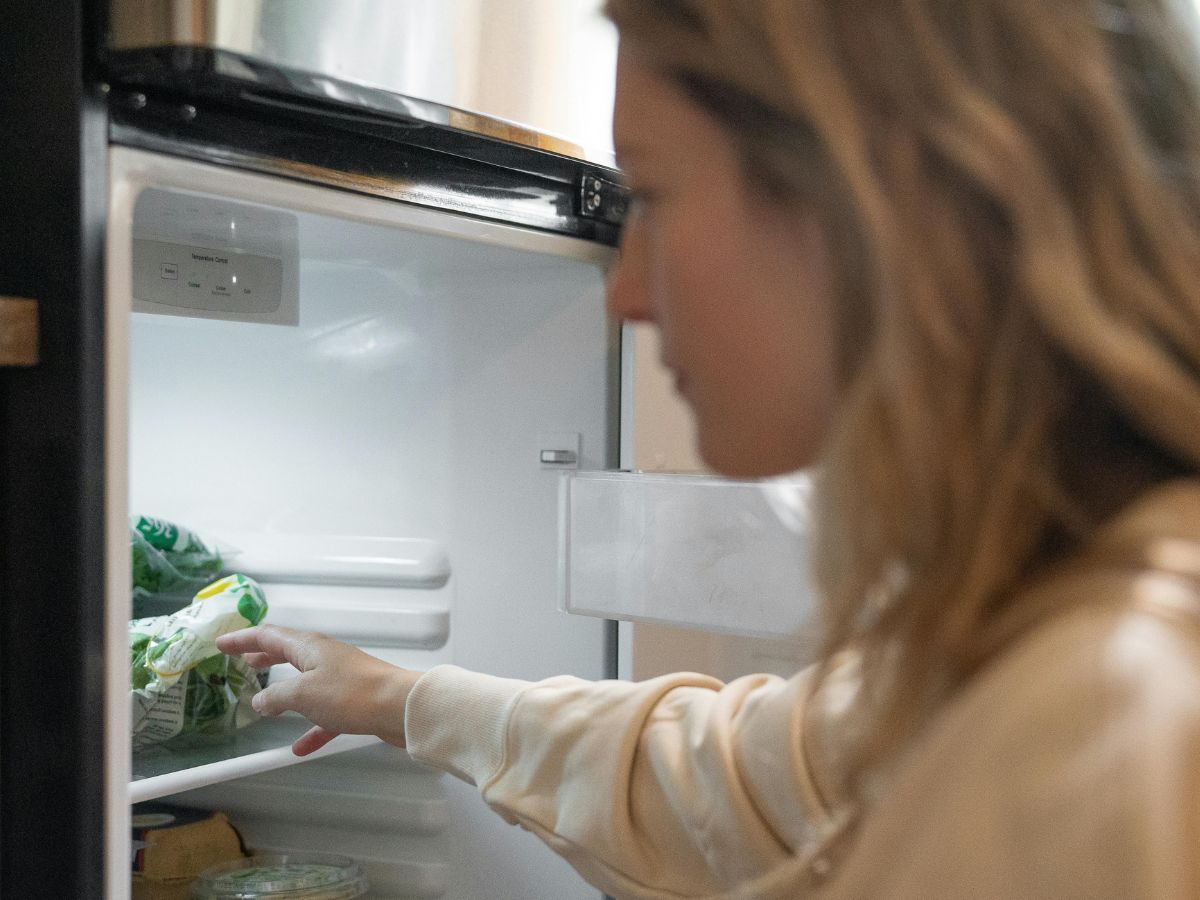close de uma mulher abrindo a geladeira