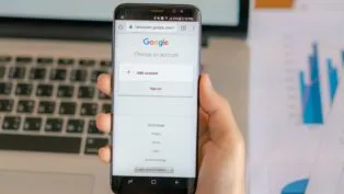 Imagem ilustrativa de uma pessoa segurando o celular com acesso ao Google