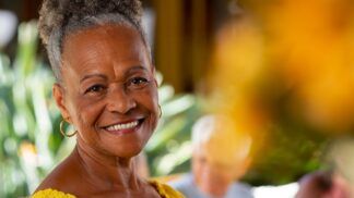 Em imagem ilustrativa, idosa sorri em foto