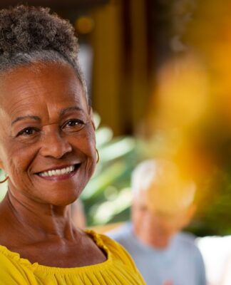 Em imagem ilustrativa, idosa sorri em foto