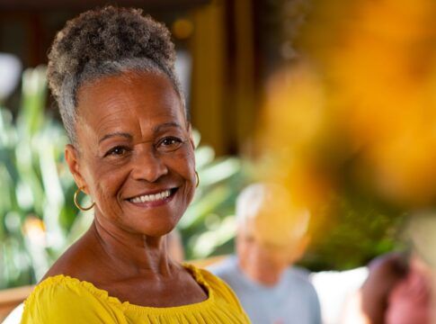 Em imagem ilustrativa, idosa sorri em foto