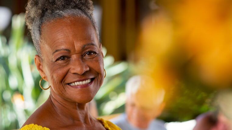 Em imagem ilustrativa, idosa sorri em foto