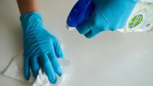 Imagem ilustrativa de uma pessoa fazendo limpeza de uma mesa