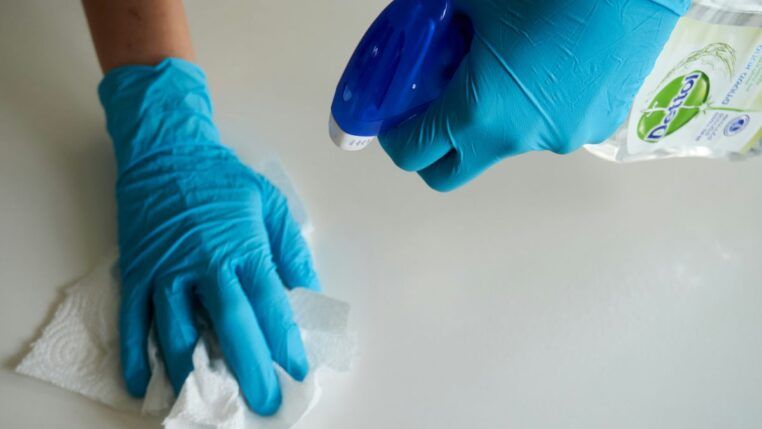 Imagem ilustrativa de uma pessoa fazendo limpeza de uma mesa