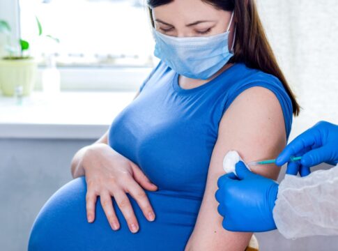 Em imagem ilustrativa, mulher gravida toma vacina