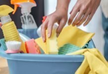 mãos de uma mulher pegando produtos de limpeza em uma caixa