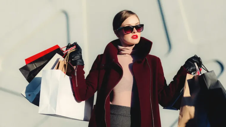 Uma mulher carrega sacolas de compras, Black Friday, promoções