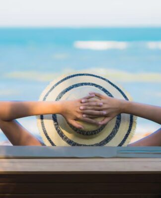 Homem na praia tomando um sol de chápeu