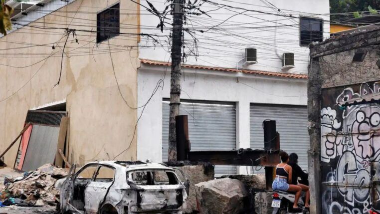 Carcaça de carro incendiado durante operação policial no Rio de Janeiro bloqueia rua
