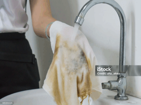 Pessoa lavando pano sujo.