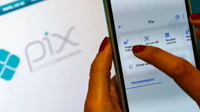 imagem de a mão de uma mulher fazendo um pix no celular