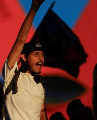 Um manifestante de punho erguido grita palavras de ordem no México, em protesto contra o governo local