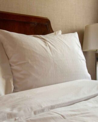 uma foto de uma cama com travesseiros bancos em cima