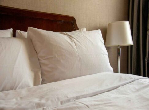 uma foto de uma cama com travesseiros bancos em cima