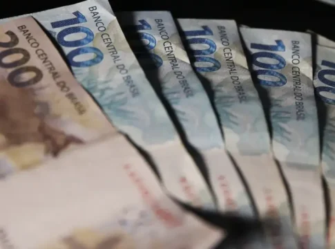 Notas de dinheiro, em reais, dispostas sobre uma superfície