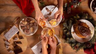 Em imagem ilustrativa, família brindam a mesa de Natal com champagne
