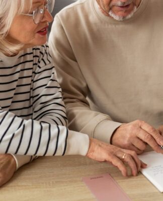 Em imagem ilustrativa, dois aposentados escrevendo em uma mesa