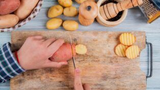 Em imagem ilustrativa, pessoas corta batatas doces para preparar o alimento