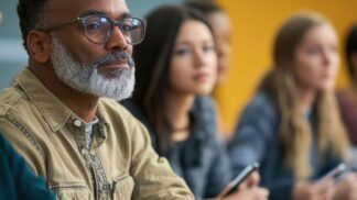 Em imagem ilustrativa, um homem escuta atentamente as orientações antes de começar a prova