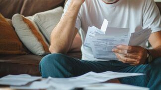 Em imagem ilustrativa, homem faz análise de suas dívidas