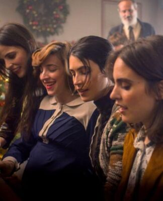 Quatro mulheres que estão tocando um piano e ao fundo está uma árvore de natal.