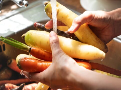 Em imagem ilustrativa, pessoa lava alimentos em água em abundância