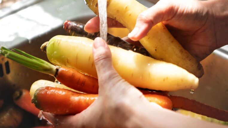Em imagem ilustrativa, pessoa lava alimentos em água em abundância