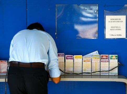 Imagem de um homem fazendo aposta em uma lotérica
