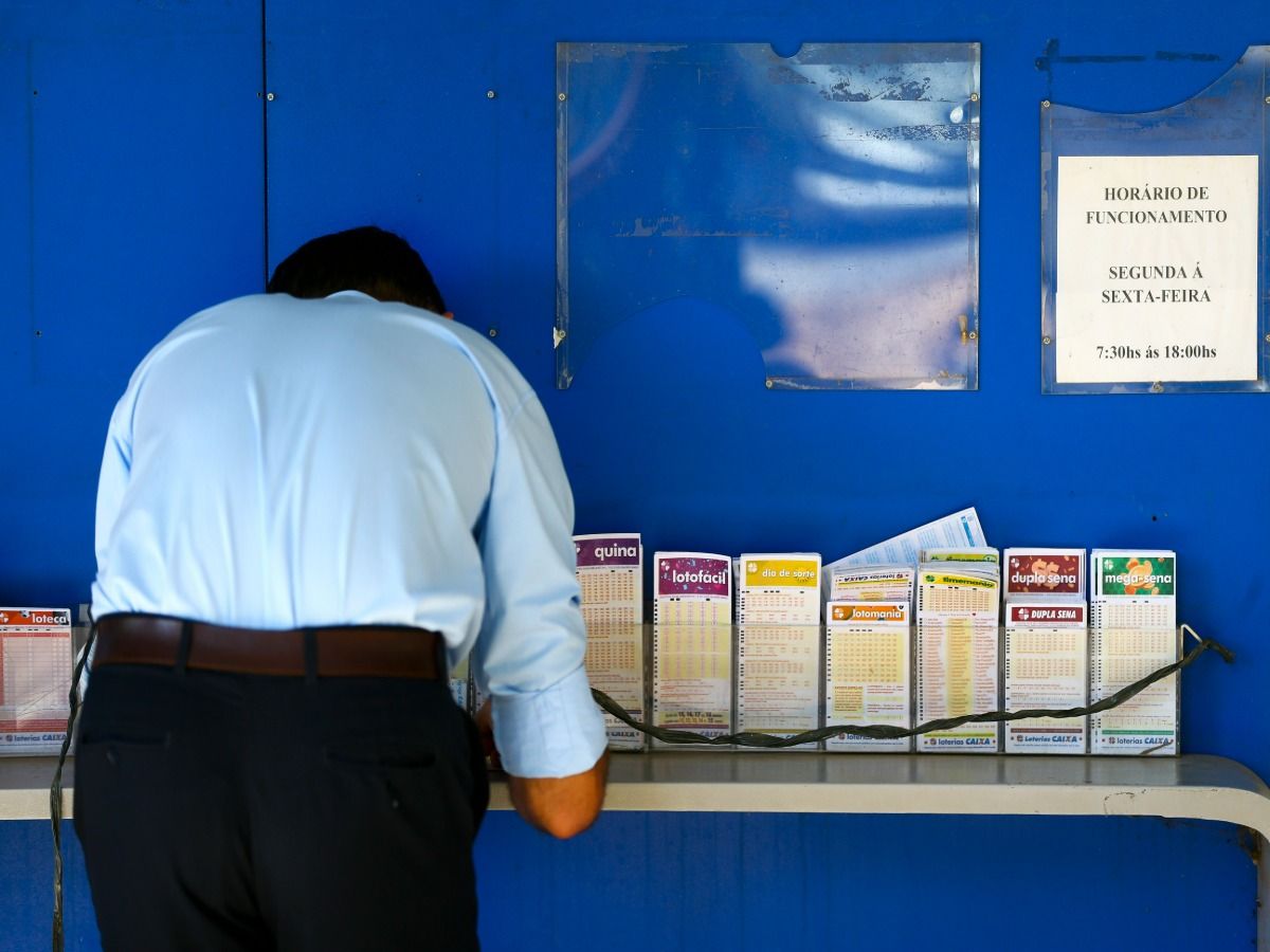 Imagem de um homem fazendo aposta em uma lotérica