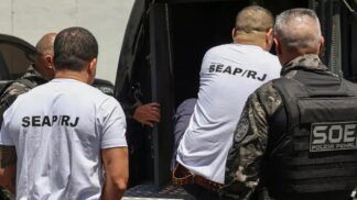 homens entrando em veículo policial para serem transferidos