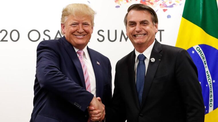 Imagem mostra Donald Trump e Bolsonaro dando as mãos