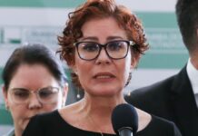 Esta é uma foto em close-up, tirada em um evento em ambiente interno, que foca na deputada federal Carla Zambelli enquanto ela discursa.