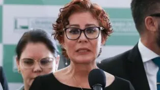 Esta é uma foto em close-up, tirada em um evento em ambiente interno, que foca na deputada federal Carla Zambelli enquanto ela discursa.