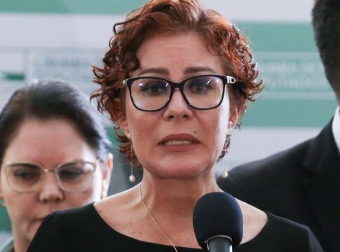 Esta é uma foto em close-up, tirada em um evento em ambiente interno, que foca na deputada federal Carla Zambelli enquanto ela discursa.