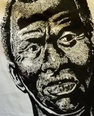 A imagem é um retrato artístico em preto e branco de Zumbi dos Palmares, estampado em um grande tecido ou bandeira de cor creme/branca. O rosto de Zumbi ocupa o centro da imagem. O estilo do desenho é de alto contraste (parecido com xilogravura ou serigrafia), usando densas áreas de preto e branco para criar textura e sombreamento.