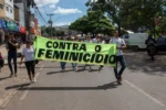 mulheres segurando faixa escrito 