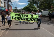 mulheres segurando faixa escrito 