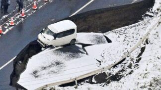 Foto tirada de um avião da Kyodo News em 9 de dezembro de 2025 mostra uma estrada desabada em Tohoku, na província de Aomori, nordeste do Japão, após um forte terremoto que atingiu a região na noite anterior.