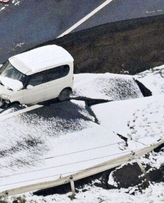 Foto tirada de um avião da Kyodo News em 9 de dezembro de 2025 mostra uma estrada desabada em Tohoku, na província de Aomori, nordeste do Japão, após um forte terremoto que atingiu a região na noite anterior.