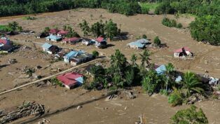 Imagem aérea mostra rastro de lama e casas destruídas por inundação