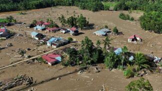 Imagem aérea mostra rastro de lama e casas destruídas por inundação