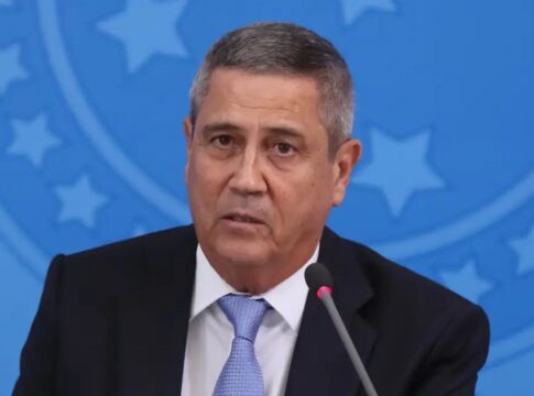 General Braga Netto fala ao microfone com símbolo militar em azul ao fundo