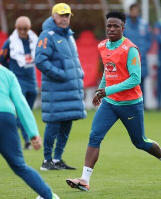 Vinícius Júnior participa de treino, sob os olhares do técnico Carlo Ancelotti ao fundo