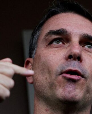 Senador Flavio Bolsonaro fala e gesticula em conversa com os jornalistas