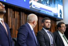Presidente da Alerj, Rodrigo Bacellar olha para cima ao lado de outros deputados na mesa da assembleia
